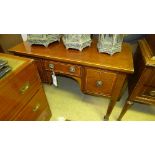 A Regency mahogany and boxwood string inlaid kneehole desk on tapered supports