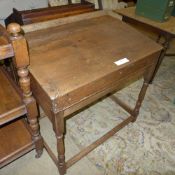 A fruitwood clerks sloping desk raised on turned supports