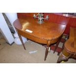 An Art Deco walnut demi-lune tea table raised on shaped supports