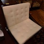 A Barcelona style chair upholstered in buttoned ivory leather in chrome frame