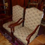 A pair of carved mahogany open armchairs upholstered in foliate fabric with studded detail and