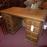 A Victorian oak pedestal desk having drop leaves an arrangement of eight graduated drawers and
