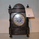 An ebonised mantel clock with a blue enamelled dial
