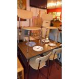 A retro faux rosewood dining table raised on chromed supports and the matching four chairs