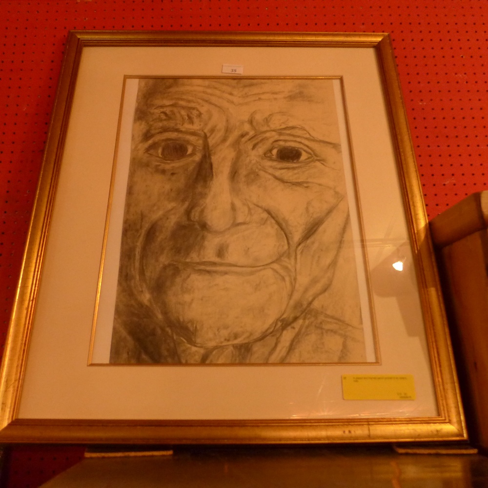 A glazed and framed pencil portrait of an elderly man