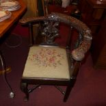 A C19th carved oak corner chair with tapestry upholstered seat and raised on stretchered supports