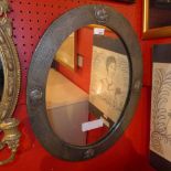 An Arts and Crafts pewter clad mirror with oval plate