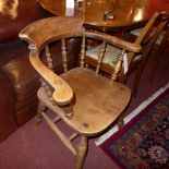 An elm smokers bow chair with solid seat raised on turned stretchered supports