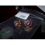 A pair of 9ct flower head form earrings with inset amythyst stones