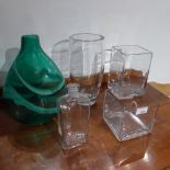 Two square glass vases, a cylindrical vase and a bottle