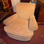 A Howard style armchair upholstered in rust coloured velour raised on turned supports