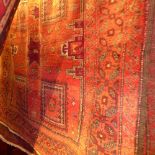 A fine North East Persian Turkoman carpet 282 x 172cm, repeating stylized Kazak motifs on a rouge
