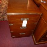 A campaign style mahogany and brass bound bedside chest fitted three drawers