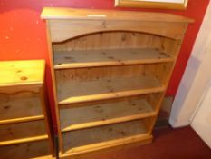 A pine open bookcase with adjustable shelves on plinth base