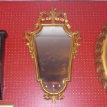 An Italian giltwood looking glass with shield shaped plate and ribbon detail