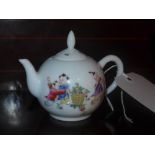 A Chinese tea pot decorated with pictoral reserves of children playing