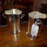 A pair of silver plated twin handled wine buckets with engraved detail