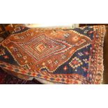 An Afghan carpet with a diamond lozenge on a brown field with blue spandrels, surrounded by