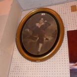 A Victorian hand tinted print of a boy in an oval gilded frame