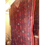 A Persian hand knotted Hamadan runner the red ground with repeating floral motifs