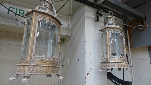 A pair of wrought iron cream painted lanterns