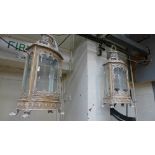 A pair of wrought iron cream painted lanterns