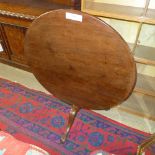 A Georgian mahogany tilt top supper table the circular top raised on tripod base