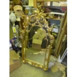 A gilded wall mirror with carved floral