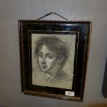 A charcoal portrait heightened in white within an eglomised frame signed T. O'Donnell