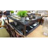 A modern bevelled glass tier low table