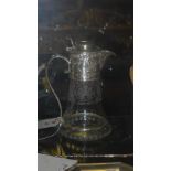 A pair of similar embossed silver plated and glass claret jugs