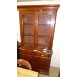A Victorian mahogany bookcase having glazed panel doors above drawers and cupboards on plinth base