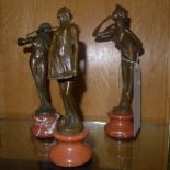 A set of three bronzed figurines of musicians on stand