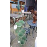 A wrought iron green painted six pot plant stand