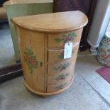 A Sheraton style demi-lune commode flanked by cupboard