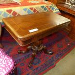 A Victorian inlaid mahogany card table the foldover top raised on reeded column and quadruped