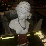 A porcelain bust of a female on a faux marble base