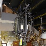 A pair of wrought iron and glass three branch hanging lanterns (one - no glass)