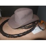 A long plaited leather whip with solid handle (length: 295 cm) and a cowboy's Stetson hat