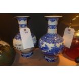 A pair of blue and white Chinese style vases with traditional village scene