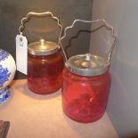 A pair of cranberry glass biscuit barrels