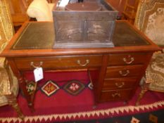 An Edwardian mahogany kneehole desk with leather lined top and  fitted five drawers raised on