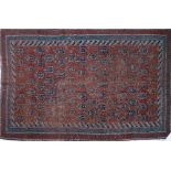 An antique Persian Afshar rug with repeating boteh motifs to madder ground within a triple border.
