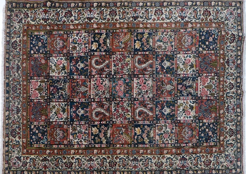 A hand woven Bakhtiari Persian carpet, the field with polychrome compartments enclosing floral