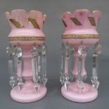 A pair of Victorian pink opaque glass lustres, with gilt detailing and faceted lustres. (some