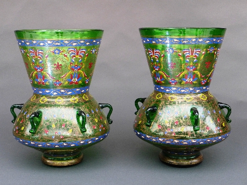 A pair of Mamluk style green and enamelled glass mosque lamps, the bulbous body on short splayed