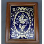 A mahogany framed Bohemian blue glass panel having engraved central vase of flowers within an oval