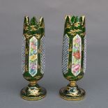 A pair of Bohemian green glass bud vases, of cylindrical form with castellated top above opaque