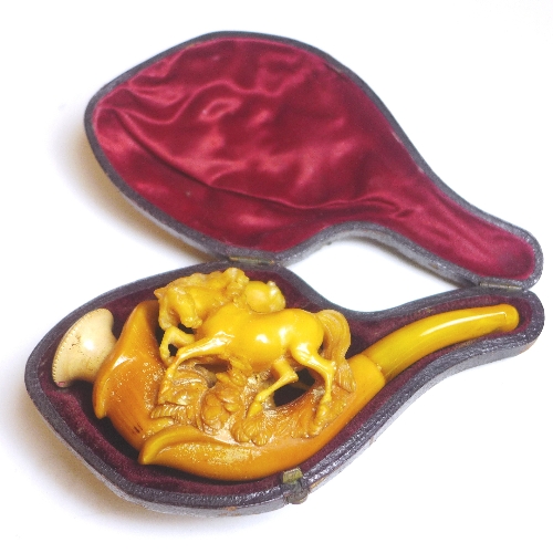 An amber coloured Meerschaum style pipe, early C20th, of mixed materials, in the form of a pair of