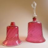 An early C20th cranberry glass bell with wreathen body and clear glass handle and one another (a/f).